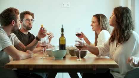 Joyful-friends-talking-while-drinking-red-wine
